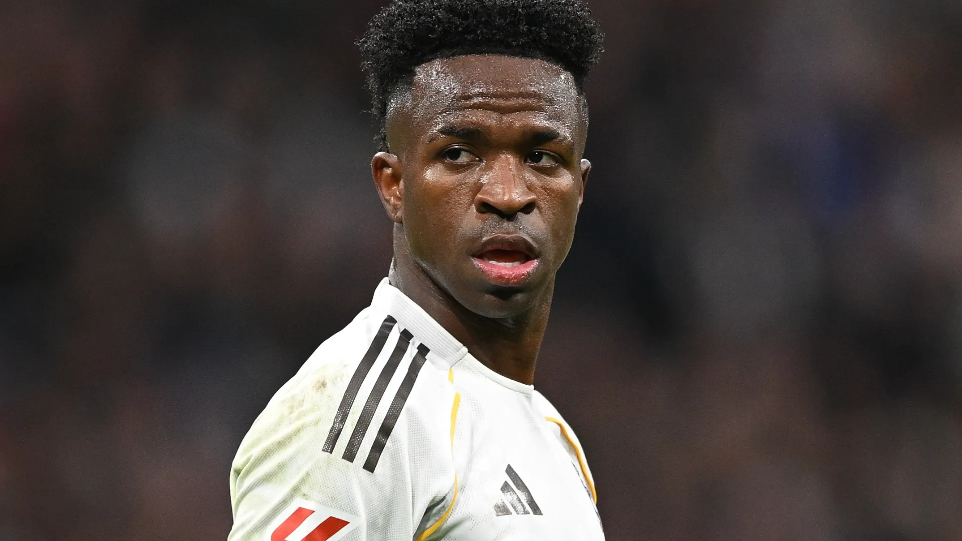 Vinicius Júnior aparece olhando para o lado durante o jogo do Real Madrid