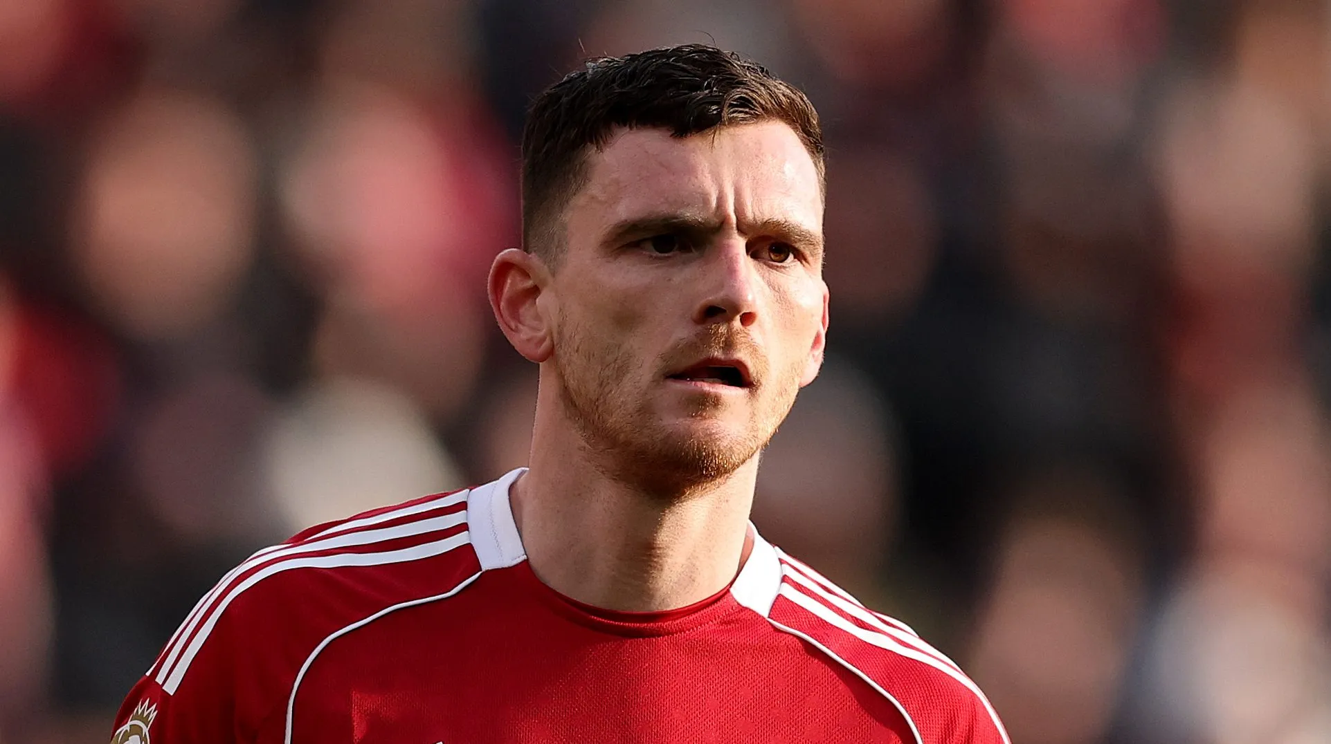 Andrew Robertson observa o jogo entre Liverpool e Tottenham Hotspur em Anfield