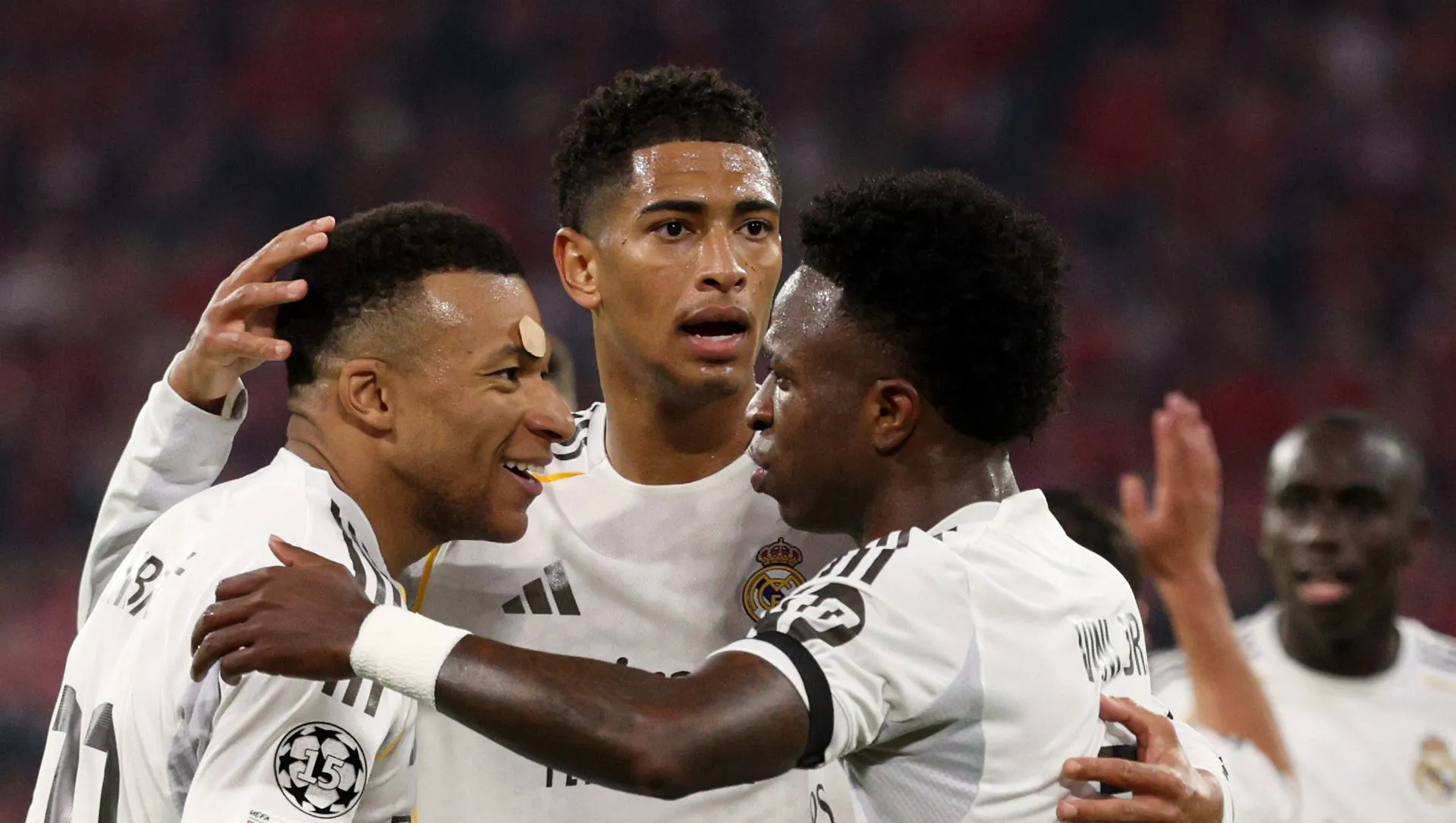 Kylian Mbappé, do Real Madrid, comemora ao marcar o terceiro gol de sua equipe com os companheiros Jude Bellingham e Vinicius Junior durante a partida de volta das quartas de final da UEFA Champions League 2025/26 entre FC Bayern München e Real Madrid CF na Football Arena Munich, em 15 de abril de 2026, em Munique, Alemanha. (Foto de Adam Pretty/Getty Images)