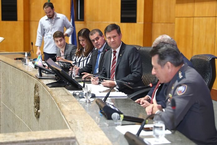 Deputados sentados atrás de mesa de reunião no Plenário Dirceu Cardoso